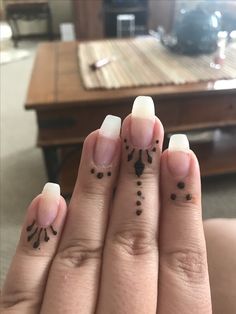 two fingers with small black dots on them and one has an upside down nail design