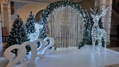 christmas decorations are displayed in front of a large window with white lights and deer figures