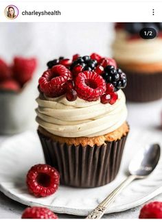 a cupcake with white frosting and berries on top