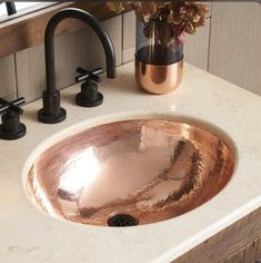 a bathroom sink with a copper colored bowl