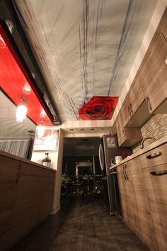 the interior of a kitchen with wooden cabinets and red lights hanging from the ceiling over the stove