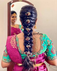 a woman with long hair in a pink sari is looking at herself in the mirror