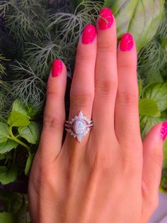 a woman's hand with pink manicured nails and a ring on her finger