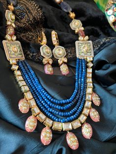 SHIVKA Special. Be Classy, Be Beautiful!! The gorgeous fusion necklace and exclusive earrings are beautifully handcrafted by our skilled Indian craftsmen from Jaipur in gold polish. Material: Blue Sapphire, Kundan,  The length of the earrings is 7 cm The drop length of the necklace is 11 inches  Necklace comes with hook closure. Notice the Tanjore artwork on cherry quartz beads, Enamelled work on side brooches Multicolor 22k Gold Fusion Jewelry, Kundan Necklace With Matching Earrings For Celebration, Gold Fusion Style Bridal Necklace With Cutdana, Festive Fusion Jewelry Sets With Matching Earrings, Luxury Meenakari Chandbali Jewelry, Blue Fusion Style Jewelry For Celebration, Kundan Necklaces With Matching Earrings For Festivals, Fusion Style Jewelry Sets With Matching Earrings For Gift, Gold Fusion Jewelry Sets With Hand Set Details