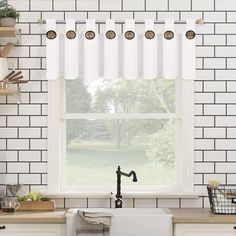 a kitchen with white brick walls and cabinets, an open window above the sink is a black faucet that has brass knobs on it