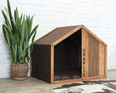 a wooden dog house next to a potted plant