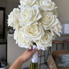 a person holding a bouquet of white roses