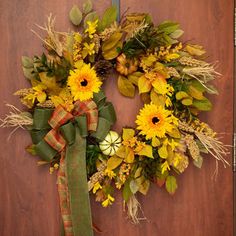 a wreath with sunflowers and leaves on a door