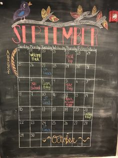 a chalk board with a calendar written on it and birds sitting on the tree branch