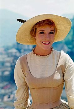 a woman wearing a hat and smiling for the camera