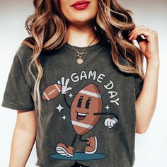 🏈 Ready to tackle game day with style? Our Comfort Colors Game Day Shirt has got your back - and your front! 🙌🍔 This shirt screams, 'I'm here for the touchdowns and tailgates!' 📣🏟️ With a hilarious football character graphic, it's the perfect way to announce your game day priorities: snacks, cheers, and more snacks! 🍕📢 Football Season is upon us, and you'll be the star player in this Football Mama Shirt. Whether you're a sports mom or just love the thrill of the game, this tee is your MVP Sporty T-shirt For Game Day During Football Season, Team Spirit Tops For Game Day Sports Season, Game Day Graphic Print Top For Sports Season, Sports Fan Tops With Team Logo For Game Day, Crew Neck Tops For Football Season Game Day, Graphic Print Tops For Game Day And Sports Season, Sporty Crew Neck Top For Tailgating, Graphic Print Top For Sports Season, Graphic Print Tops For Game Day