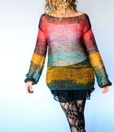 a woman is walking down the runway wearing tight stockings and a colorful knitted sweater