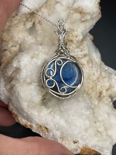 This is a beautiful blue Labradorite moon pendant in Sterling Silver. A complimentary stainless steel chain is included and a gift box, ready for shipping.  All of my pieces are made with high quality wire from Riogrande. These are not costume pieces that will chip away or rust over time. They will last forever if taken care of, which is why I include a free polishing cloth with every order. Quality is very important to me.  If you have any questions, I'm happy to help Wire Wrapped Round Pendant Jewelry As Gift, Wire Wrapped Pendant Jewelry Gift, Wire Wrapped Pendant Jewelry For Gifts, Amulet Style Jewelry With Natural Stones For Gifts, Natural Stone Amulet Jewelry As Gift, Silver Celestial Jewelry With Cabochon, Celestial Silver Jewelry With Cabochon, Silver Celestial Jewelry For Her, Natural Stones Jewelry Gift