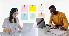 two people sitting at a table with laptops and headphones