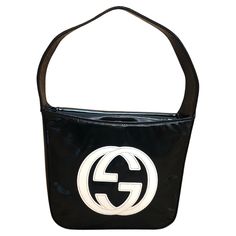 This vintage GUCCI Mini Hobo Handbag is crafted of patent leather in black featuring a massive white GG interlock logo at the front. Top flap magnetic snap closure opens to a coated interior which has been professionally cleaned featuring a patch pocket. Made in Italy. Measures approximately 7.5 x 6 x 2.5 inches Handle drop 5 inches. Comes with dust bag. Condition - Exterior in good vintage condition. Interior professionally cleaned Outside: Some creases on patent leather Inside: Professionally cleaned and fit to use Smell: No odor Structured Shoulder, Gucci Mini, Hobo Handbag, Hobo Handbags, Fashion Handbags, Vintage Gucci, Patch Pocket, Patent Leather, Dust Bag