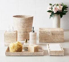 the bathroom accessories are arranged neatly on the white counter top, with flowers in the background