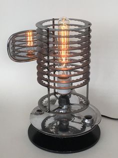 an old fashioned table lamp with two light bulbs on the top and one is turned on