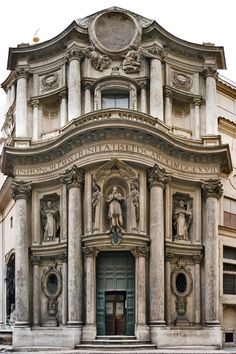 an old building with statues on the front and side of it's entrance door