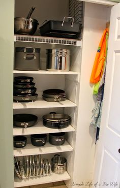 an organized pantry with pots and pans