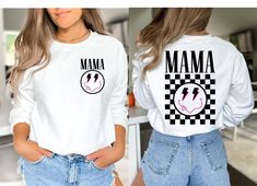 "Introducing our stylish and comfortable Crewneck Sweatshirt/Graphic Tee featuring a black or white checkered happy face design with a unique twist! The front showcases a lightning bolt-eyed happy face that proudly says \"Mama,\" while the back features a checkered happy face design with the word \"Mama\" for a cool and eye-catching look. It has bold pink features on the happy face. Our Crewneck Sweatshirt/Graphic Tee is made with high-quality materials to ensure durability and comfort. The blac Face Graphic, Sweatshirt Graphic, Stylish Shirt, Vintage Tee, Trendy Shirts, Workout Sweatshirt, Face Design, Happy Face, Lightning Bolt