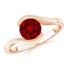 a gold ring with a red stone in the middle and a curved band around it