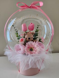 a pink vase filled with flowers on top of a table