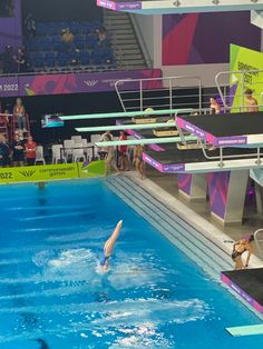 an olympic swimming event with swimmers in the pool and onlookers watching from the stands