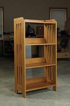 a wooden book shelf sitting inside of a room