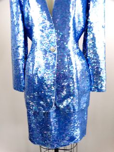 "This is an EXQUISITE hand sewn sequin dress and jacket! This ensemble is fully embellished with iridescent bright blue sequins. It's in perfect condition! Jacket Bust - 38/40\" Jacket Waist - 30\" Jacket Length - 29\" Skirt Waist - 28\" Skirt Hips - 40\" Skirt Length - 20\" This dress comes from a pet-free and smoke-free home. If you would like more info or have any questions, please don't hesitate to ask!" Blue Sequin Dress For Spring Formal, Elegant Blue Sequin Fabric For Formal Occasions, Blue Sequin Fabric With Contrast Sequin For Spring, Blue Sequin Fabric With Contrast Design For Spring, Blue Contrast Sequin Fabric For Spring, Fitted Blue Sparkling Sequin Dress, Blue Long Sleeve Sequin Dress For Formal Events, Blue Long Sleeve Sequin Dress For Formal Occasions, Blue Sequin Fabric For Formal Occasions