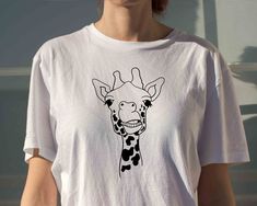 Description Giraffe Shirt, Animal Lover Gift, Animal Shirt, Animal Gift Idea, Adopt Animal Shirt, Animal Lover T-shirt, Gift for Animal Lovers     HOW TO ORDER      1. Check photos for sizing and color options  2. Select size and color from the drop-down menus  3. Add to cart & Place order  4. Your shirt is now off to production and will be ready for shipment in 1-3 days!      SHIRT SIZING    All shirts come in 12+ colors and 6 sizes, ranging from Small to 3X-Large.    PRODUCTION & SHIPPING    O Playful Graphic Print Shirt For Gifting, Playful Graphic Print Shirt As Gift, Playful Graphic Print Shirt For Gift, Playful Graphic Print Shirt As A Gift, Playful T-shirt With Funny Print As Gift, Unisex Tops With Funny Print Gift, Unisex Funny Print Top For Gift, Novelty Custom Print T-shirt For Gift, White Novelty Tops As Gift