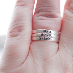 Sterling Silver Skinny Rings Faith, Hope, Love Skinny Rings that are handcrafted and sterling in every sense. They're more than jewelry—they're a daily nod to what matters. Jewelry with Meaning In a whirlwind world, these rings serve as a quaint little reminder of what sticks - faith, hope, and love. Each ring carries its own potent reminder, stamped thoughtfully into its subtle shine. Stack ‘em or Solo ‘em Their sleek design allows them to be your right-hand, er, ring for any occasion. Dress th Faith Hope And Love, With Meaning, Faith Hope Love, Hope Love, Heartfelt Gifts, Faith Hope, Love Ring, Handmade Sterling Silver, Sterling Ring