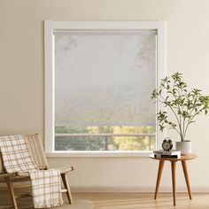 a chair and table in front of a window with the blinds pulled down to let light shine through