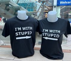 "I'm With Stupid Shirt / Matching Couple Shirts / Funny Sarcastic T Shirt / Short Sleeve Sarcasm Tee Gift / Couple Apparel  This cute and comical \"I'm With Stupid\" t-shirt set is the perfect choice for couples who want to showcase their playful dynamic in style. Featuring a classic unisex t-shirt design, both of the shirts reads \"I'm With Stupid\"  Crafted from comfortable and breathable cotton, these shirts are ideal for any activity, from running errands to a night out on the town. The shirts come in a variety of sizes, making it easy to find the perfect fit, and the stylish black color ensures that the shirts will always be in style.  Whether you're shopping for a fun couples gift for a special occasion, or you're simply looking for a way to add a little humor to your wardrobe, this Best Friend Shirts Funny Boys, Matching Couple Shirts Funny, Funny Couples Shirts, Fitted Black Shirt With Funny Text, Matching Outfits Couples, Couples Shirts Funny, Couple Shirts Relationships, Matching Shirts Couple, Drawing Generator