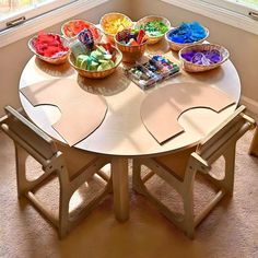 a wooden table topped with lots of different types of candies in bowls on top of it