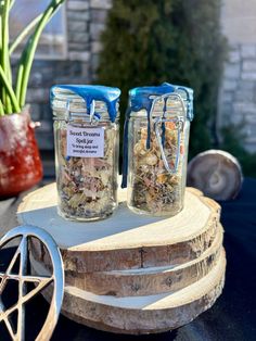 two mason jars filled with dried herbs on top of a table