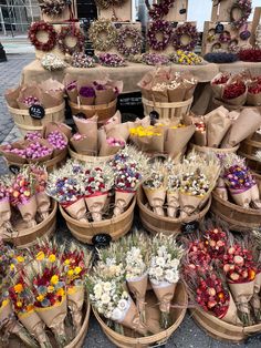 many different types of flowers are arranged in baskets