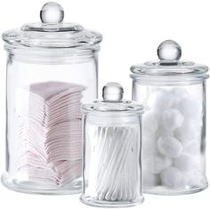 three glass jars filled with different types of candy and cotton swabs on top of each other