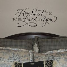 a bedroom with a bed and wall decal that says how sweet it is to be loved by you