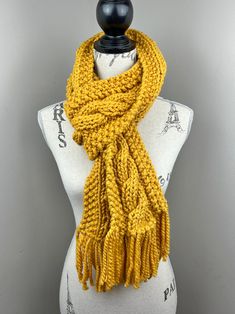 Handmade knit scarf  Yarn is 80% acrylic 20% wool Color: mustard  Width is 5 inches  Length is 80 inches with fringe  Care Instructions: Hand wash and lay flat to dry. Yellow Winter Scarf, One Size, Yellow Winter Scarf One Size, Scarf With Fringe, Scarf Yarn, Handmade Knit, Handmade Knitting, Knit Scarf, Lay Flat, Cable Knit