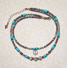 Boho style layered necklace created using Dalmation Jasper gemstone beads, turquoise Howlite stone beads, red Japanese Picasso seed beads, tiny turquoise seed beads, antique copper accents throughout, and an antique copper peace sign charm.  The longest strand measures approximately 17", and the shortest strand measures approximately 15-1/2". Adding an additional 2", the extender chain is finished with a small copper charm.  The peace sign charm measures 1/2" x 1/2". For matching earrings, click on the link below: https://www.etsy.com/listing/1779229641/copper-peace-sign-earrings-gemstone-and?click_key=284c28ea52e49b3ffa4e26bbd353bff23e91a64a%3A1779229641&click_sum=1d1d9a2e&ref=shop_home_active_1&frs=1 Thank you for shopping with The Lucie Collection! Turquoise Bohemian Beaded Necklaces For Layering, Turquoise Bohemian Beaded Necklace For Layering, Bohemian Turquoise Necklaces For Layering, Adjustable Multi-strand Bohemian Turquoise Necklace, Bohemian Jewelry With Tiny Beads For Layering, Bohemian Multi-strand Adjustable Turquoise Necklace, Adjustable Bohemian Multi-strand Turquoise Necklace, Bohemian Double Strand Turquoise Necklace, Blue Double Strand Bohemian Turquoise Necklace