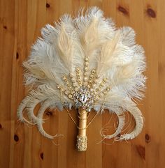 there is a feather and bead bouquet on the floor next to a wooden wall