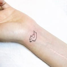 a woman's arm with a small tattoo of a fox on the left wrist