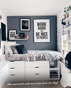 a bedroom with white and gray walls, pictures on the wall