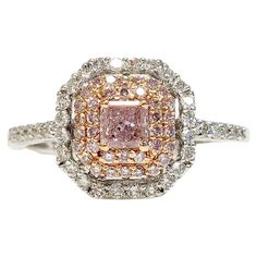 a fancy pink diamond ring with white and yellow diamonds in the center, on a white background