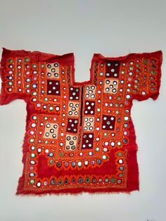 an orange piece of cloth with circles and dots on it, sitting on a white surface