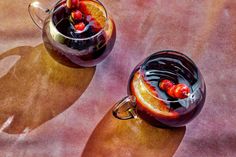 two glasses filled with liquid sitting on top of a table