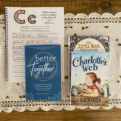 two books are sitting on a doily next to some writing paper and an envelope