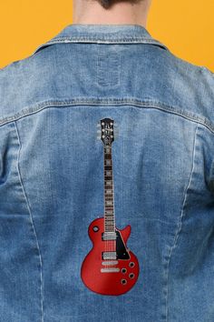 the back of a man's jean jacket with an electric guitar embroidered on it