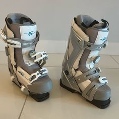 two snowboard boots sitting on top of a white tile floor next to each other