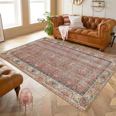 a living room filled with furniture and a large rug on the floor next to a couch